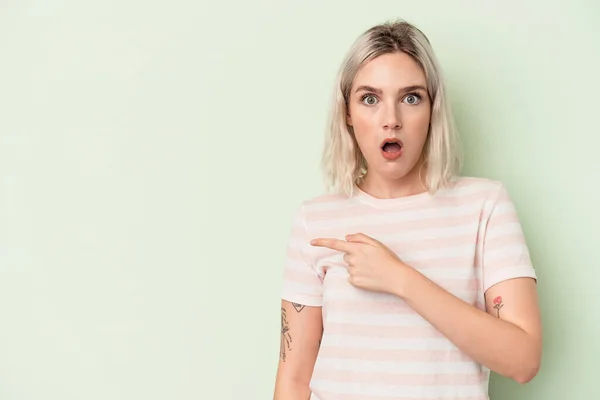 Mujer Joven Caucásica Aislada Sobre Fondo Verde Apuntando Hacia Lado — Foto de Stock