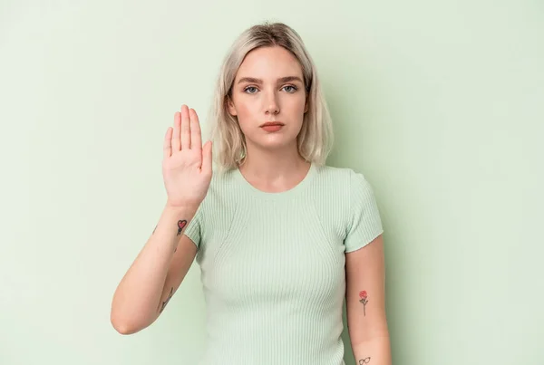 若いです白人女性隔離された緑の背景に立って手を伸ばして停止記号を示す あなたを防ぎます — ストック写真
