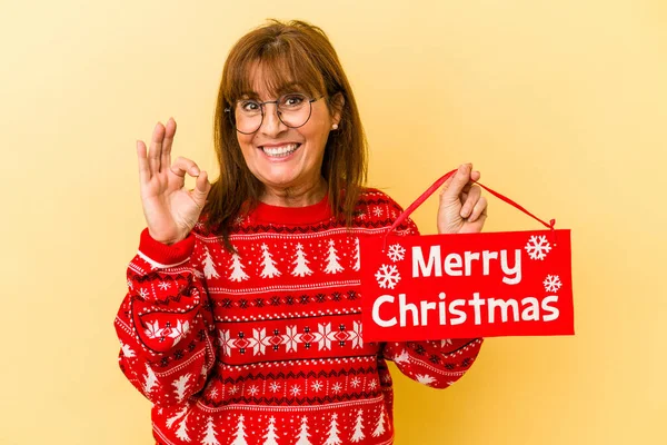 Middle Age Caucasian Woman Holding Merry Christmas Placard Isolated Yellow — Stock Photo, Image