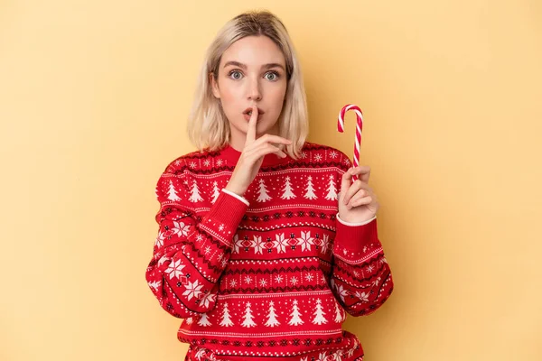 Mladá Běloška Drží Vánoční Klacek Izolované Žlutém Pozadí Udržet Tajemství — Stock fotografie