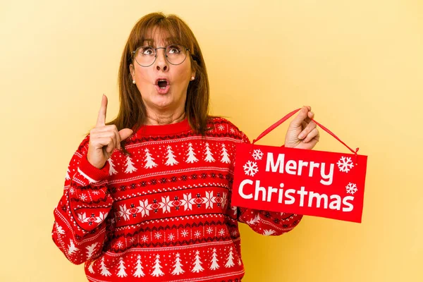 Middle Age Caucasian Woman Holding Merry Christmas Placard Isolated Yellow — Stock Photo, Image
