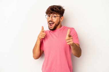 Genç melez adam, gri arka planda soyutlanmış neşeli gülücükler öne bakıyor..