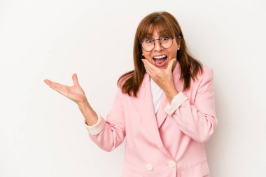 Beyaz arka planda izole edilmiş orta yaşlı beyaz kadın avuç içinde fotokopi alanı tutuyor, el üstünde tutuyor. Şaşırmış ve mutlu..