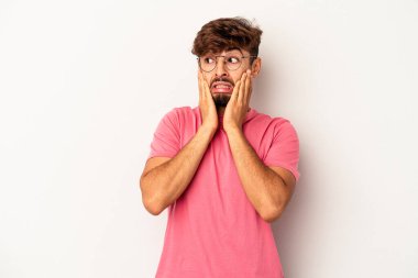 Genç melez adam gri arka planda izole edilmiş korkmuş ve korkmuş..