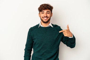 Genç melez adam, gri arka planda izole edilmiş. Elle bir gömlek fotokopi alanını gösteriyor. Gururlu ve kendinden emin.