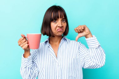 Mavi arka planda pembe kupa tutan melez bir kadın hoşlanmadığı bir hareket gösteriyor. Anlaşmazlık konsepti.