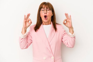 Beyaz arka planda izole edilmiş orta yaşlı beyaz kadın yoğun bir günün ardından rahatlıyor, yoga yapıyor..