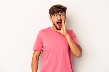 Genç melez adam, gri arka planda izole edilmiş, heyecanlı bir şekilde bağırıyor..