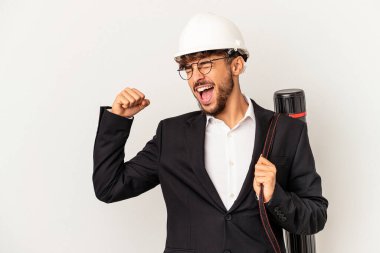 Gri arka planda izole edilmiş kask takan genç mimar zafer kazandıktan sonra yumruğunu kaldırdı..