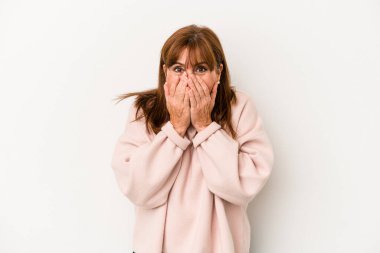 Beyaz arka planda izole edilmiş orta yaşlı beyaz kadın bir şeye gülüyor, elleri ağızda..