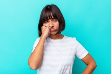 Mavi arka planda izole edilmiş genç melez kadın tekrarlanan bir görevden yoruldu..