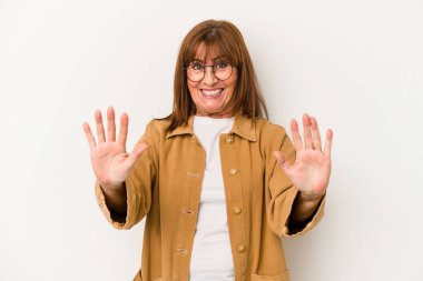 Beyaz arka planda izole edilmiş orta yaşlı beyaz kadın on numarayı elleriyle gösteriyor..