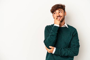 Genç melez adam, gri arka planda izole edilmiş rahat bir şekilde fotokopi odasına bakan bir şeyi düşünüyor..
