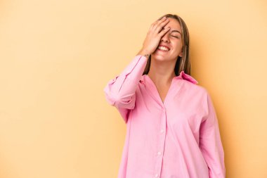 Sarı arka planda izole edilmiş genç beyaz kadın gülüyor, kaygısız, doğal duygu..