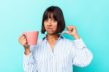 Mavi arka planda pembe kupa tutan genç bir ırk kadını gururlu ve kendinden emin hissediyor, örnek olarak..