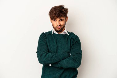 Genç melez adam, gri arka planda izole edilmiş hoşnutsuzca kaşlarını çatmış, kollarını kavuşturmuş..