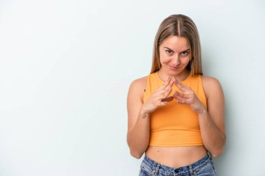 Kafkasyalı genç bir kadın mavi arka planda izole edilmiş bir plan kuruyor, bir fikir kuruyor..