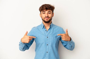 Genç melez adam, gri arka planda izole edilmiş. Elle bir gömlek fotokopi alanını gösteriyor. Gururlu ve kendinden emin.