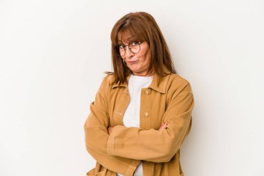 Beyaz arka planda izole edilmiş orta yaşlı beyaz kadın kameraya alaycı bir ifadeyle bakıyor..