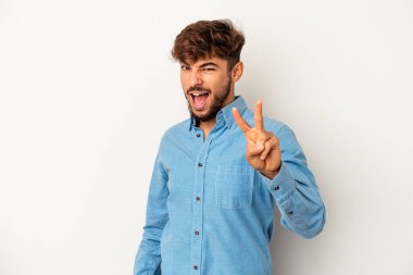 Genç melez adam gri arka planda izole edilmiş. İki numarayı parmaklarıyla gösteriyor..