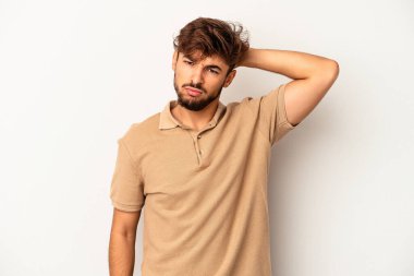 Genç melez adam gri arka planda izole edilmiş. Çok yorgun ve uykulu. Elini başının üstünde tutuyor..