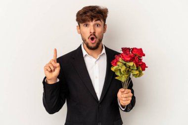 Beyaz arka planda izole edilmiş gül buketi tutan genç melez adamın harika bir fikri var, yaratıcılık kavramı..