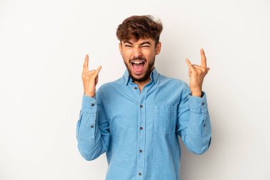 Genç melez adam gri arka planda izole edilmiş boynuzları bir devrim konsepti olarak gösteriyor..