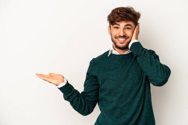 Gri arka planda izole edilmiş genç melez avuçlarında fotokopi alanı tutuyor, el üstünde tutuyor. Şaşırmış ve mutlu..