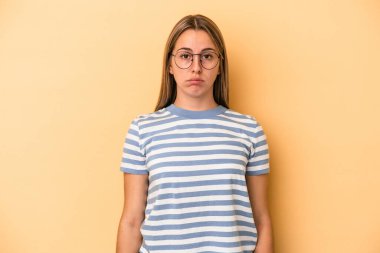 Sarı arka planda soyutlanmış beyaz bir kadın üzgün, ciddi bir yüz, mutsuz ve hoşnutsuz.