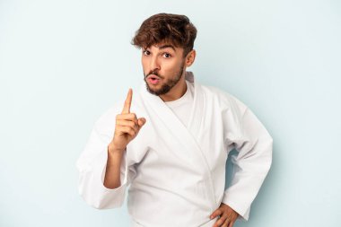 Mavi arka planda karate yapan genç melez bir adamın bir fikri, ilham konsepti var..