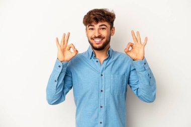 Genç melez adam gri arka planda izole edilmiş neşeli ve kendinden emin..