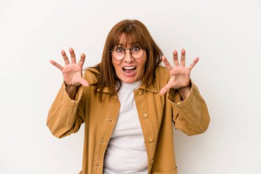 Beyaz arka planda izole edilmiş orta yaşlı beyaz kadın pençelerini kedi taklidi yaparken gösteriyor, agresif bir hareket..