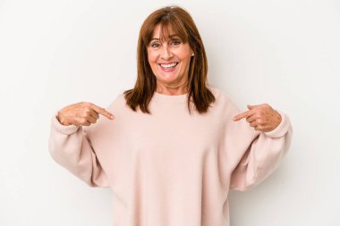 Beyaz arka planda izole edilmiş orta yaşlı beyaz kadın parmağını gösterip gülümseyerek şaşırdı..