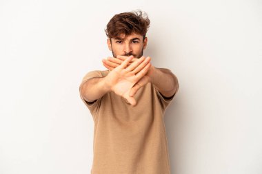 Gri arka planda izole edilmiş genç melez bir adam inkâr jesti yapıyor.