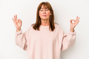 Beyaz arka planda izole edilmiş orta yaşlı beyaz kadın yoğun bir günün ardından rahatlıyor, yoga yapıyor..