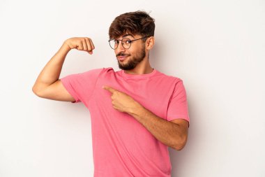 Gri arka planda izole edilmiş genç melez kadın gücünün sembolü olan kollarla güçlü bir hareket gösteriyor.