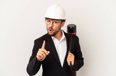 Gri arka planda izole edilmiş bir kask takan genç mimar bir fikri, ilham verici bir konsepti var..