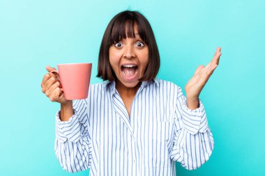 Mavi arka planda pembe kupa tutan genç bir ırk kadını hoş bir sürprizle karşılaşıyor, heyecanlı ve el kaldırıyor..