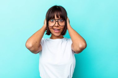 Genç melez kadın mavi arka planda izole edilmiş bağırıyor, çok heyecanlı, tutkulu, bir şeyden memnun..