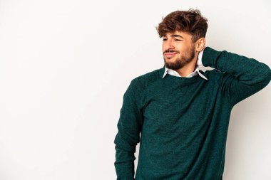 Genç melez adam gri arka planda izole edilmiş kafasının arkasına dokunuyor, düşünüyor ve bir seçim yapıyor..