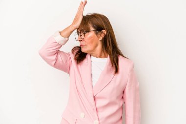 Beyaz arka planda izole edilmiş orta yaşlı beyaz kadın bir şeyi unutuyor. Alnına avuç içi ve kapalı gözlerle vuruyor..