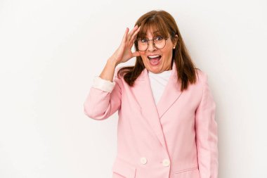 Beyaz arka planda izole edilmiş orta yaşlı beyaz kadın yüksek sesle bağırıyor, gözleri açık ve elleri gergin tutuyor..
