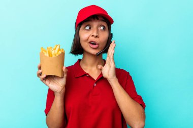 Mavi arka planda patates kızartması tutan genç ve melez bir restoran çalışanı gizli bir sıcak fren haberinin olduğunu söylüyor.