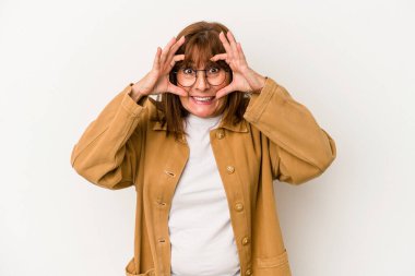 Beyaz arka planda izole edilmiş orta yaşlı beyaz kadın bir başarı fırsatı bulmak için gözlerini açık tutuyor..