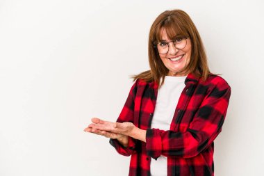 Beyaz arka planda izole edilmiş orta yaşlı beyaz kadın palmiye üzerinde bir kopya alanı tutuyor..