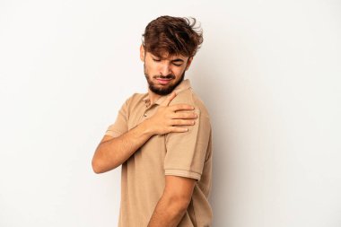 Genç melez adam, gri arka planda izole edilmiş, omuz ağrısı çekiyor..