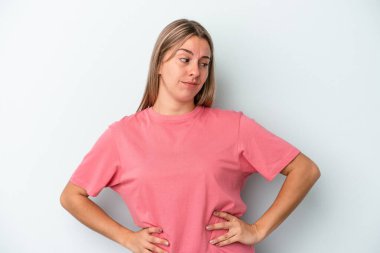 Kafkasyalı genç bir kadın mavi arka planda izole edilmiş, kafası karışmış, şüpheli ve kendinden emin değil..