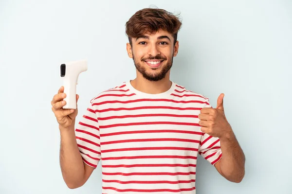 Joven Hombre Raza Mixta Sosteniendo Termómetro Aislado Sobre Fondo Azul — Foto de Stock