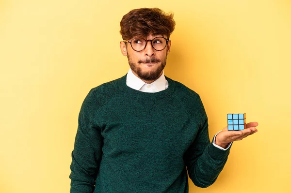 Mladý Smíšené Rasy Muž Drží Rubiks Kostka Izolované Žlutém Pozadí — Stock fotografie