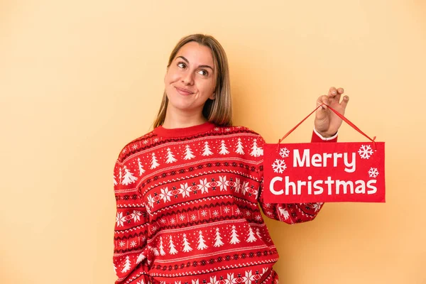 Mladá Běloška Drží Veselé Vánoční Plakát Izolované Žlutém Pozadí Snění — Stock fotografie